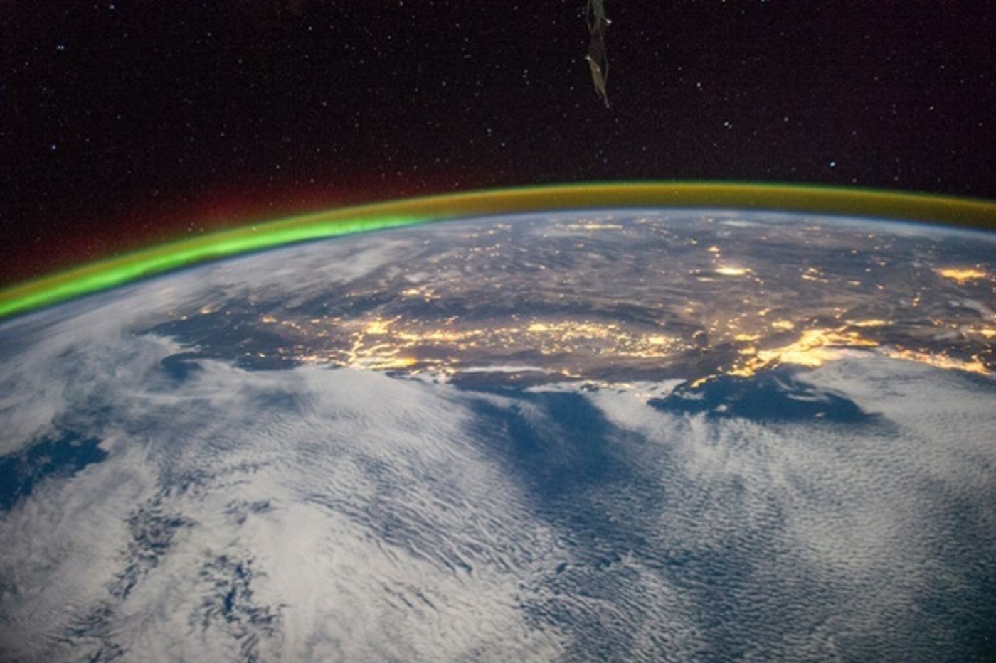 Night over Los Angeles, the Central Valley, and the Sierra Nevada, and Salt Lake City with a green aurora (left) on the horizon