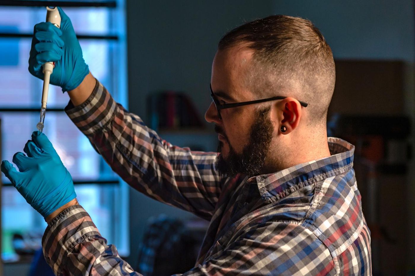 Rice University graduate student Joseph Massey sets up an experiment to study the WNT signaling pathway in developing cell lines. The pathway plays a central role in cell differentiation as organisms develop. /Credit: Jeff Fitlow/Rice University