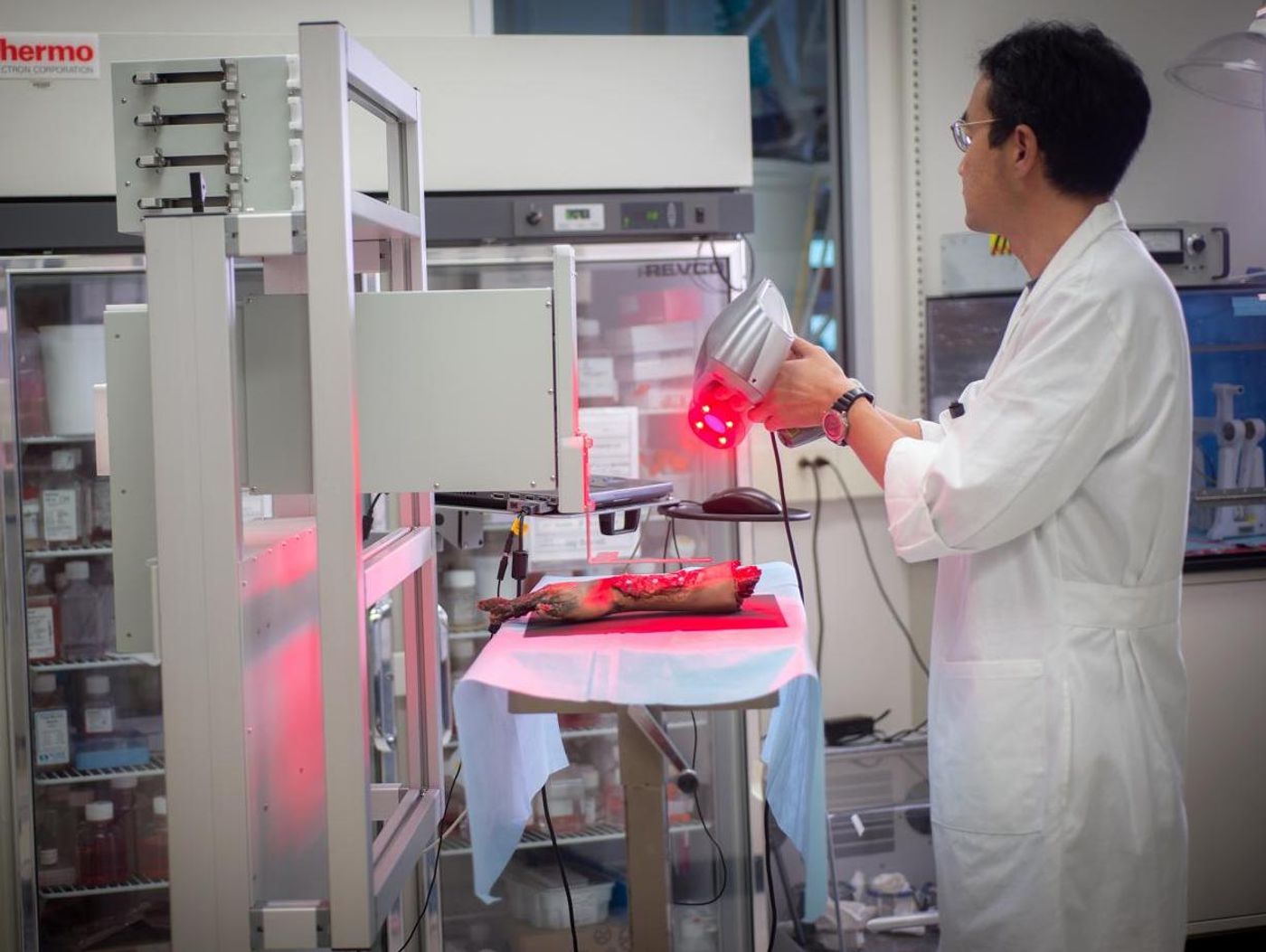 A WFIRM technician operates the mobile bio printer for skin printing on a limb demo./ Credit: WFIRM Photo