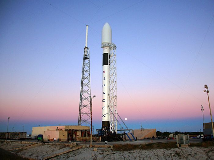 A SpaceX Falcon 9 rocket standing tall at a launch site.