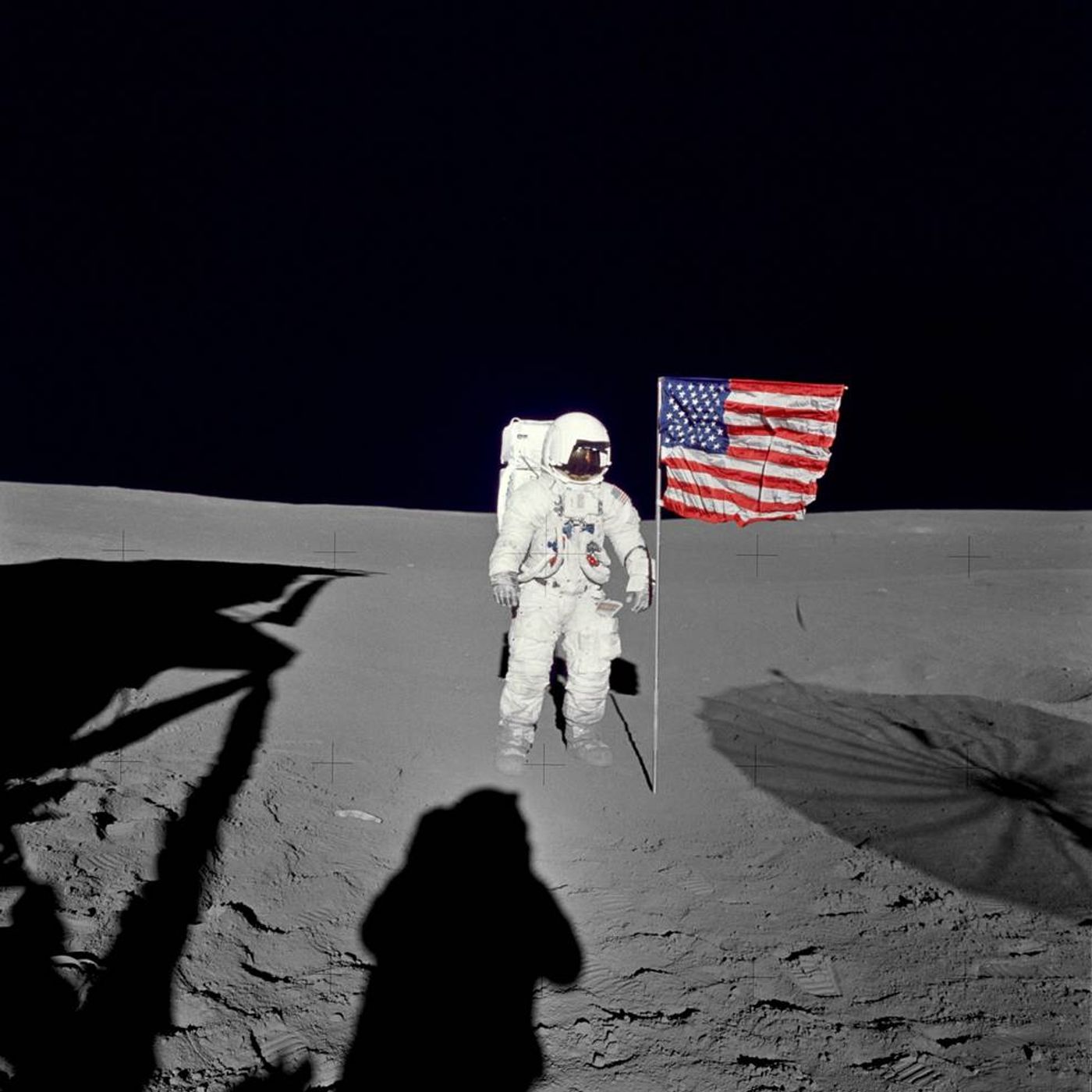 Mitchell stands beside an American flag on the Moon's surface.