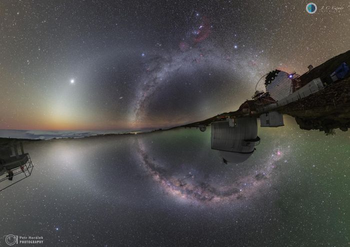 (In the upper portion of this amazing composite image,) The Observatory of the Roque de los Muchachos Observatory on the Canary Islands and (lower) the sky in the southern hemisphere from the La Silla Observatory in Chile. The Milky Way is vertical above and below the horizon. Venus is immersed in Zodiacal Light, which produces a complete circle. Andromeda and the Magellanic Clouds can also be seen. / Credit: Juan Carlos Casado and Petr Horálek