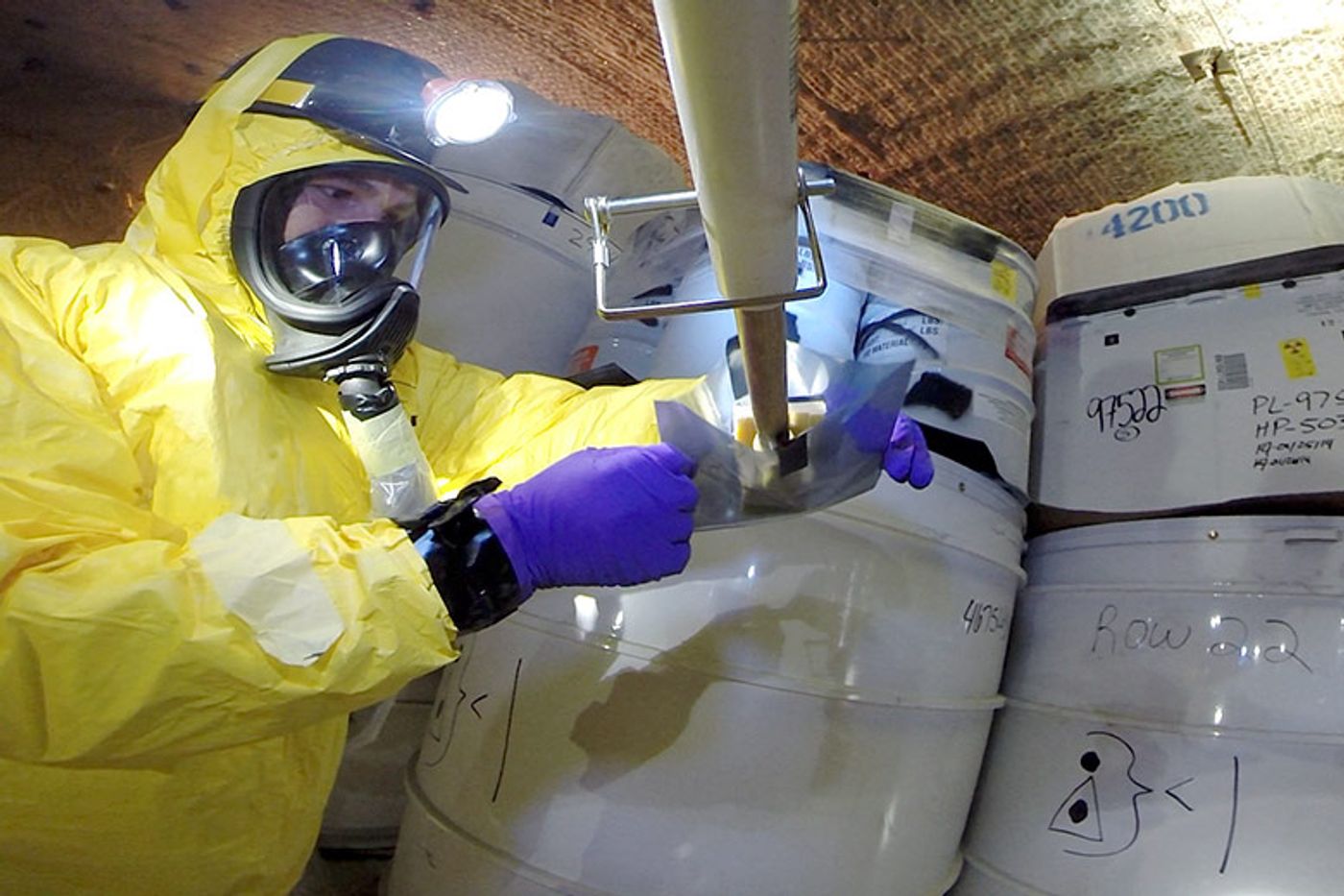 A recovery worker obtains samples from a damaged drum after a safety incident in May 2014 at the Waste Isolation Pilot Plant in New Mexico.