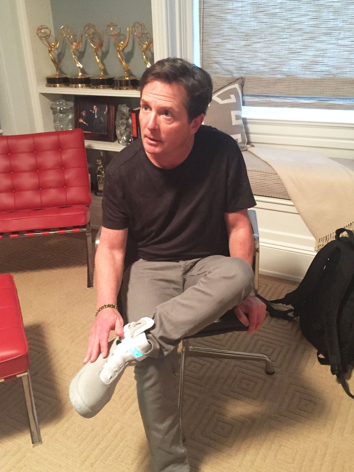Michael J. Fox puts on a Nike self-lacing shoe.