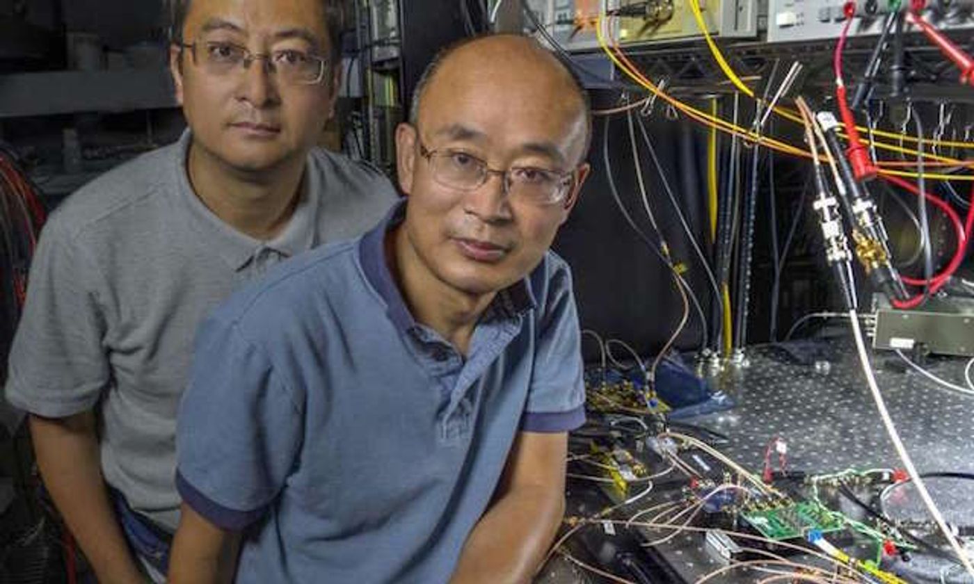 Guan Yang (right) and his research associate, Wei Lu, in front of their new laser communications system