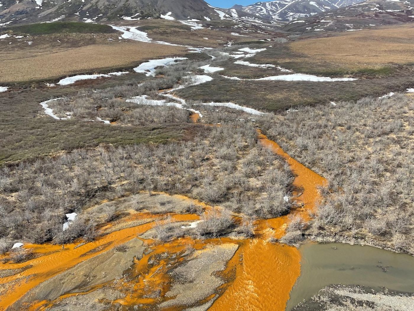 Photo of an orange stream in the Brooks Range of northern Alaska, discolored by oxidized iron and heavy metals. by Josh Koch, Courtesy of the U.S. Geological Survey
