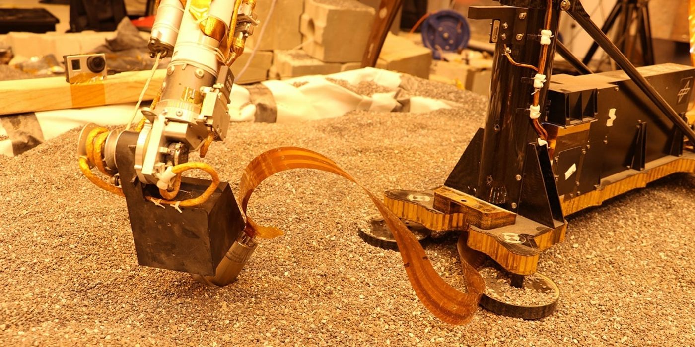 A demo shows an identical robotic arm pressing down on a near-identical mole during testing.