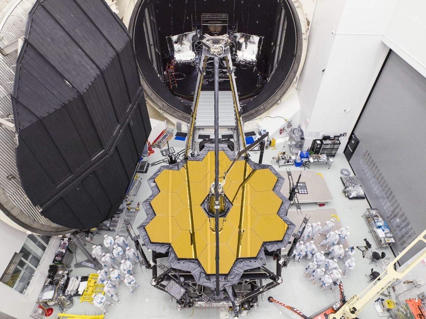 Engineers stand next to the massive heart of the James Webb Space Telescope after removing it from NASA's Chamber A testing facility in Houston, Texas.