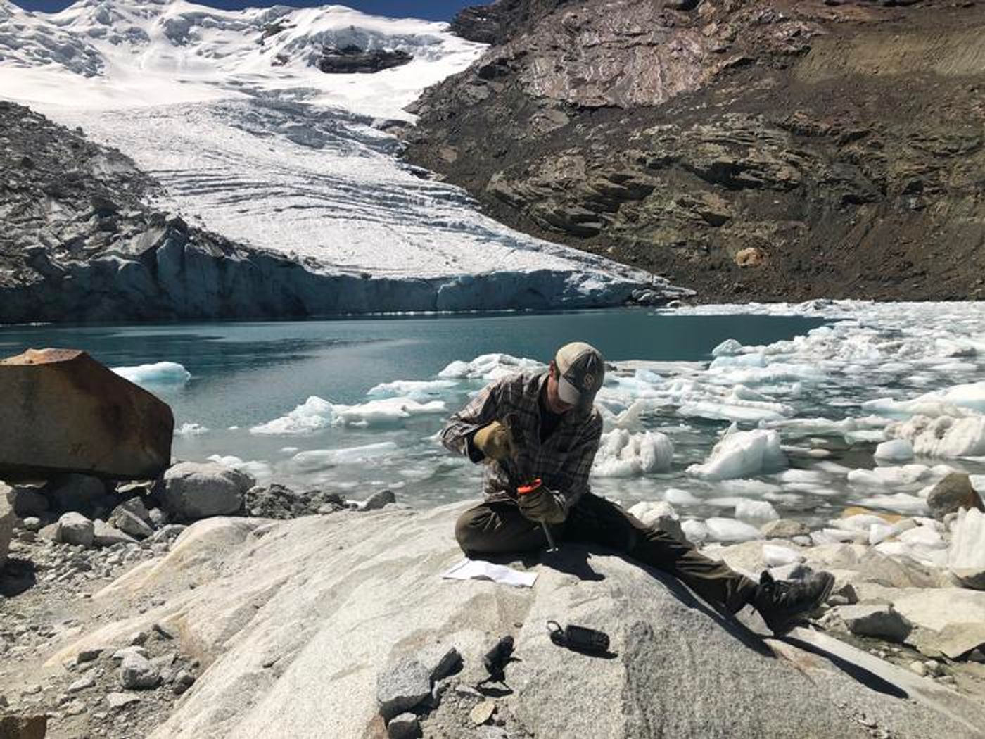 A researcher collects a sample of bedrock from the Queshque Glacier in the Peruvian Andes Mountains. Credit: Emilio Mateo, Aspen Global Change Institute