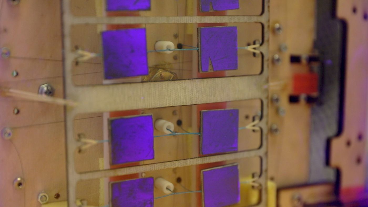 The purple squares are grippers using gecko-inspired physics to grab onto objects.