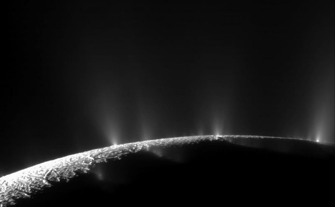 The water vapor plumes of Saturn's moon Enceladus emanating from its south pole. Image Credit: NASA/JPL/Space Science Institute