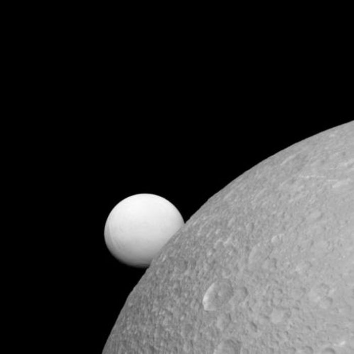 Enceladus (background), and Dione (foreground); two of Saturn's moons as pictured by Cassini.