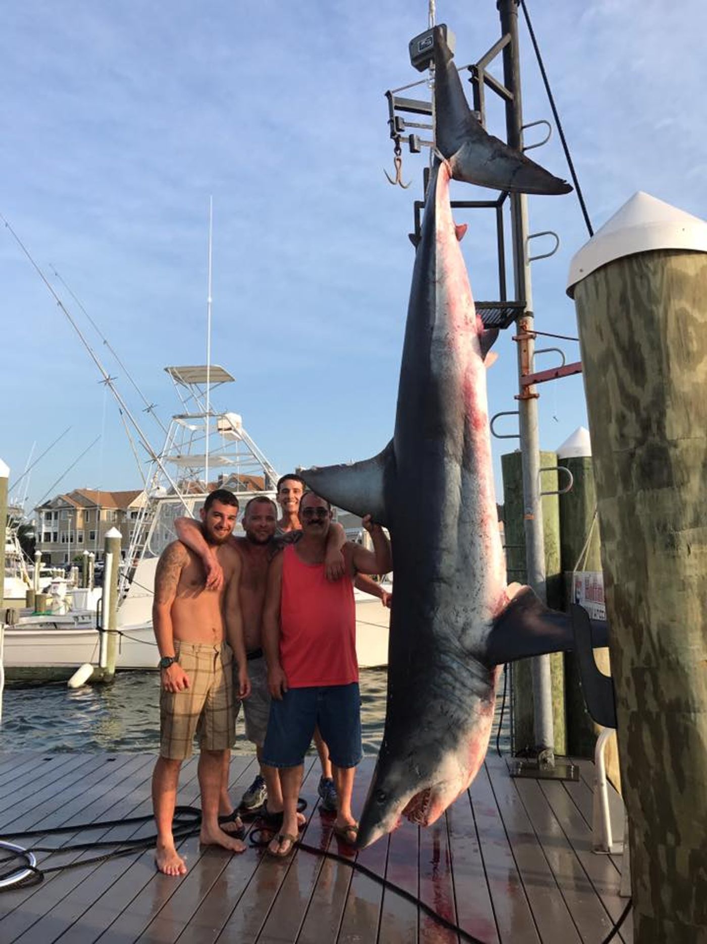 The crew of the Jenny Lee charter boat pose with their massive 926-pound Mako shark catch.
