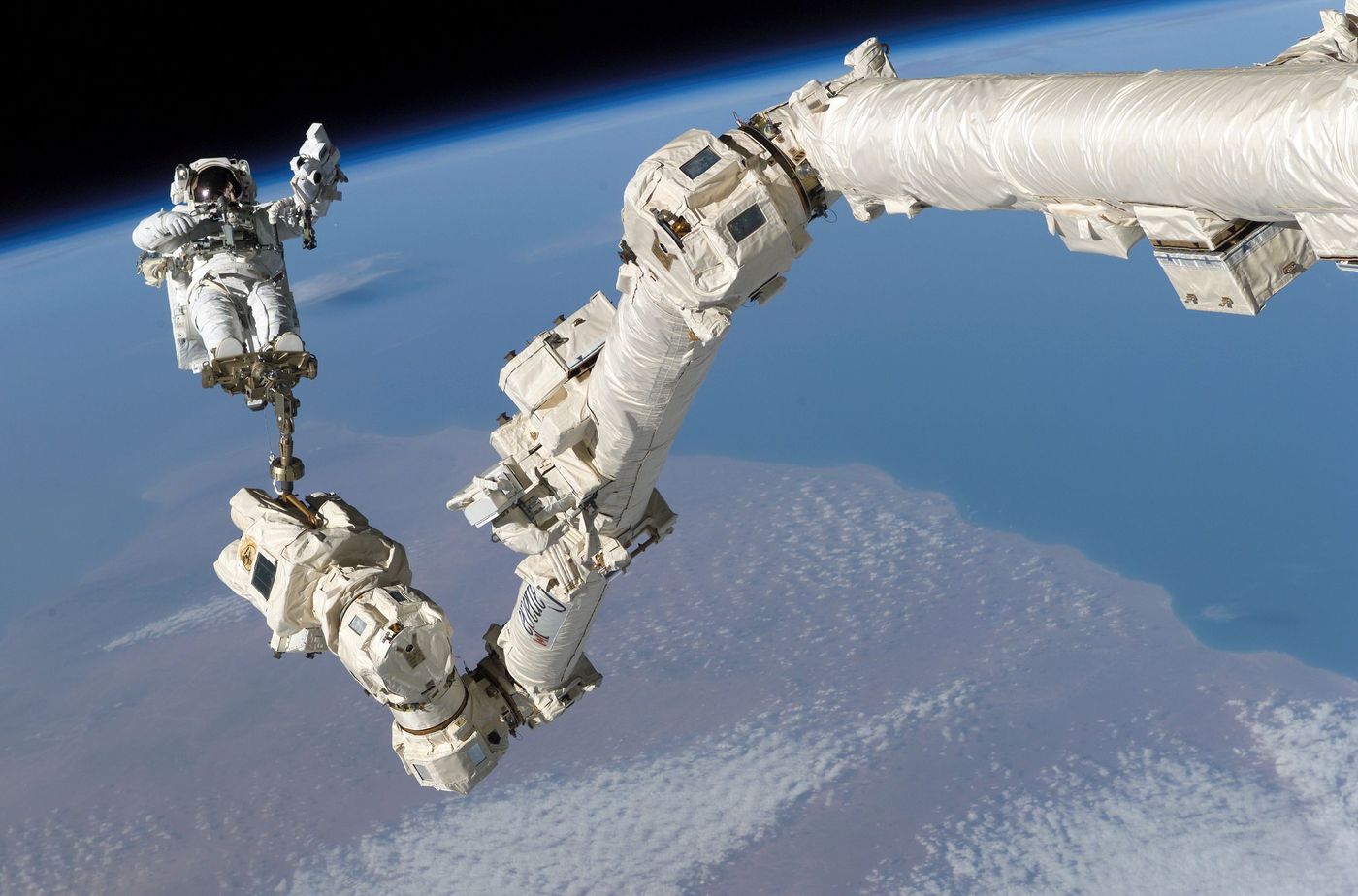 Canadarm2 pictured back in 2005, along with astronaut Steve Robinson.