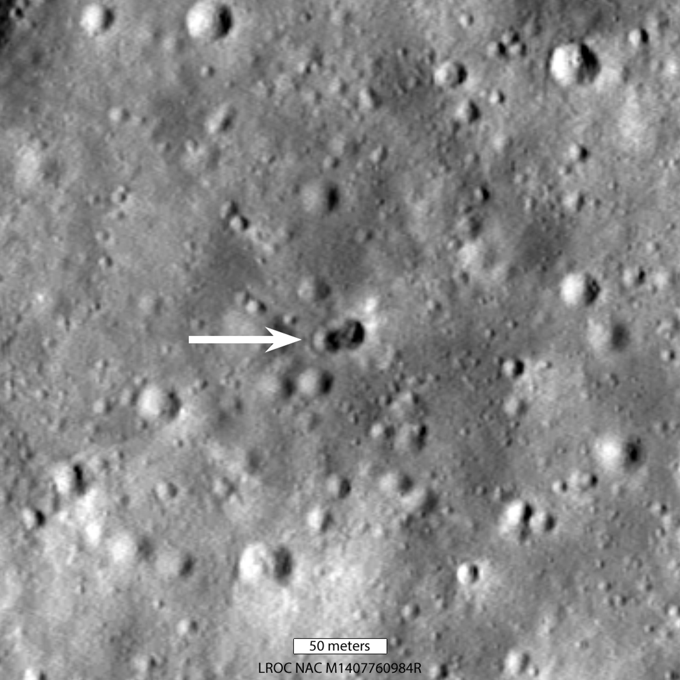 The crater created by a rocket body impacting the Moon, as indicated by the arrow. Credit: NASA/Goddard/Arizona State University