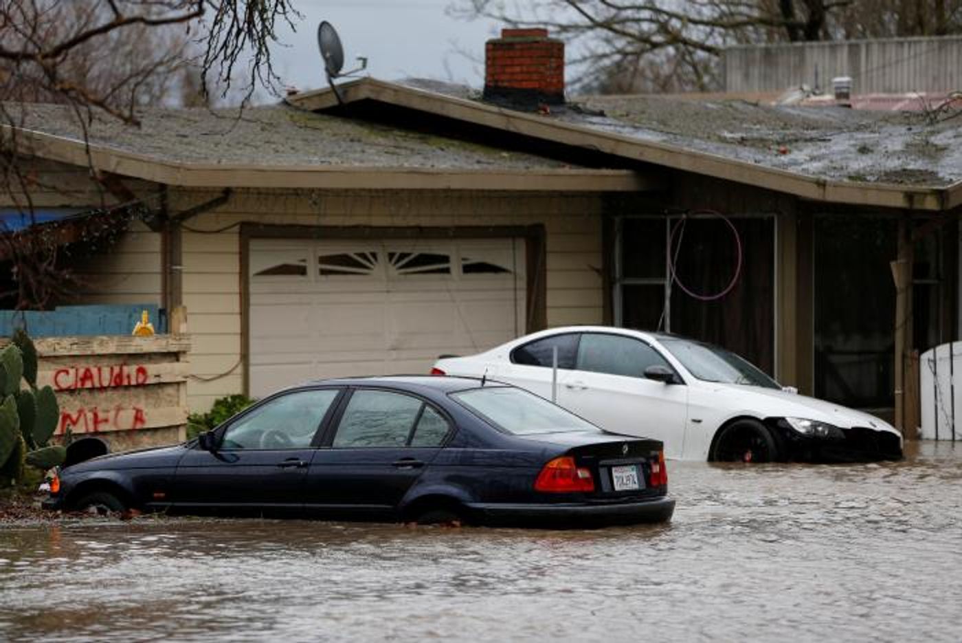 A partially submerged home and vehicles are seen during a winter storm in Petaluma, California, January 8, 2017. REUTERS/Stephen Lam