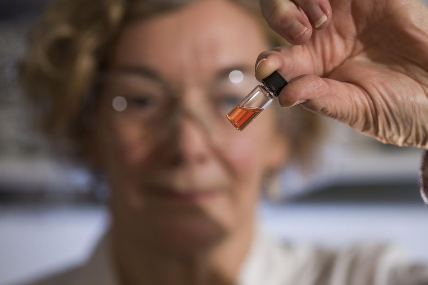 Biogeochemistry Lab Manager Janet Hope from the ANU Research School of Earth Sciences holds a vial of pink colored porphyrins representing the oldest intact pigments in the world. / Credit: The Australian National University