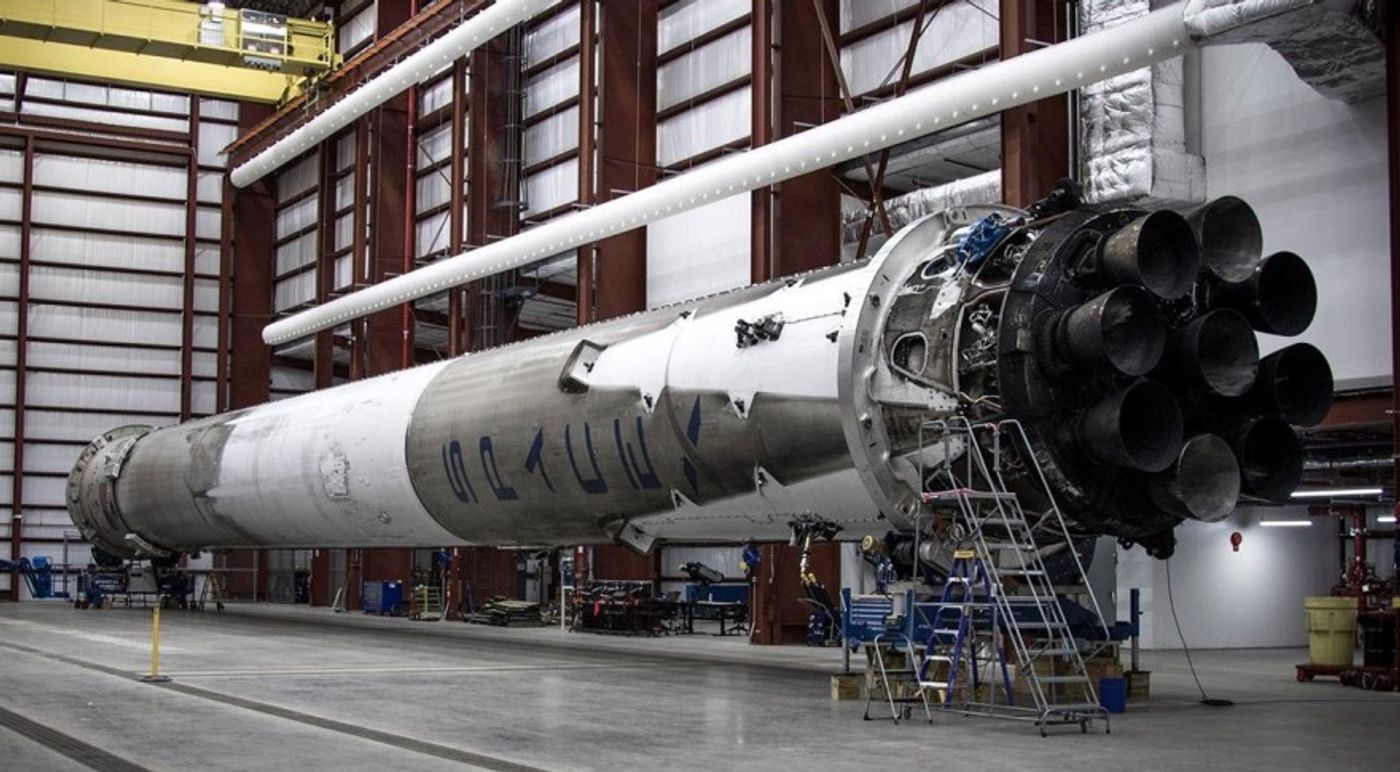The SpaceX Falcon 9 reusable rocket that blasted off last month sits sideaways in a hangar.