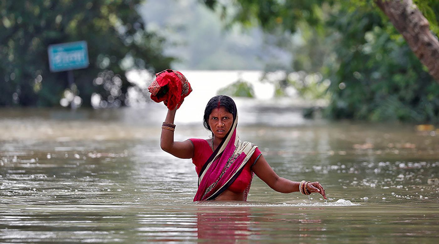 A woman wades through a flooded village in the eastern state of Bihar, India August 22, 2017. © Cathal McNaughton / Reuters.