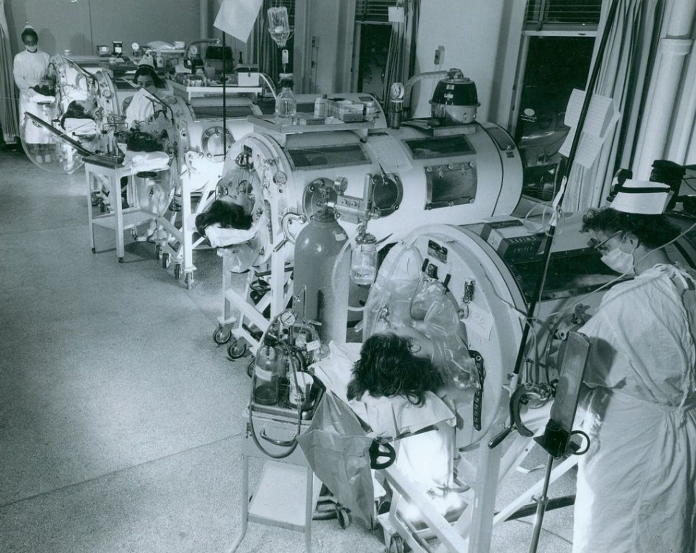 In the 1950s, the Iron Lung machines seen in this photo helped people breathe when polio virus killed their lung muscle cells