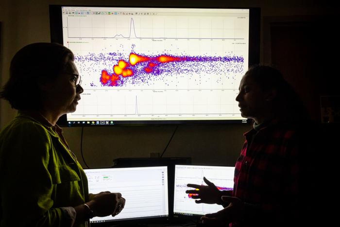 Diana Aga (left) and her PhD student Minduala Wijayahena anaylze an ion chromatogram that demonstrates the bacteria's biodegration of a forever chemical. / Credit: Meredith Forrest Kulwicki/University at Buffalo