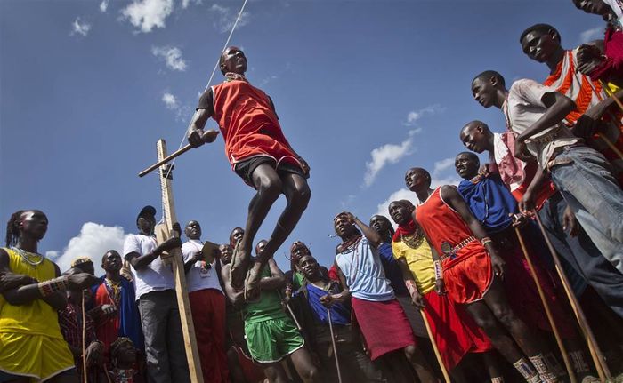 A Maasai warrior makes the high jump, not in Olympic fashion but in Maasai warrior-style, a vertical jump from a standing position. Athletes must touch a high line with the top of their heads.  Photo: Ben Curtis/AP