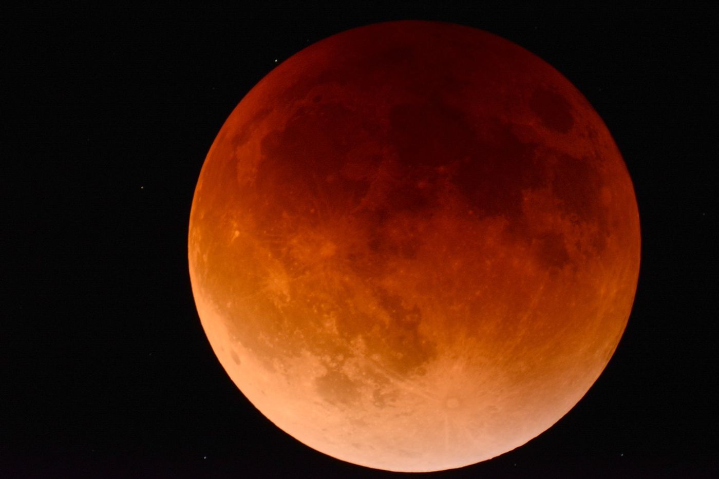 This picture depicts a Blood Moon, which happens when the Earth blocks the Sun's light from reaching the lunar surface.