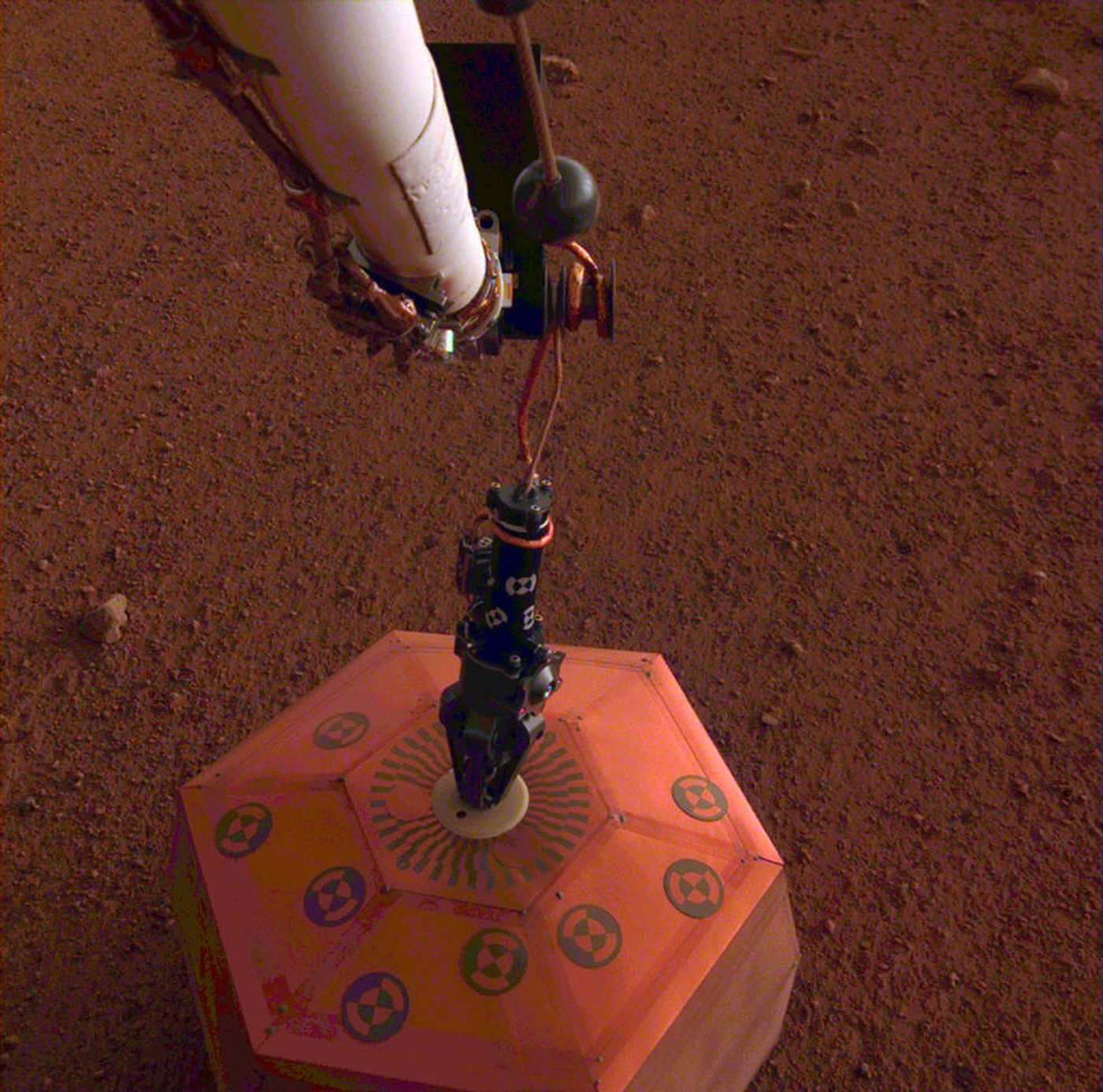 A picture of InSight's SEIS instrument in the soil beside the lander.
