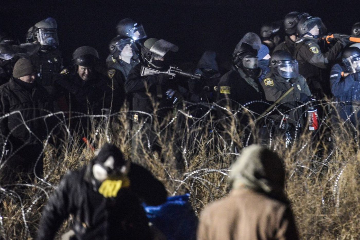 Police confront protesters with a rubber bullet gun during a protest at Standing Rock. Photo: PBS