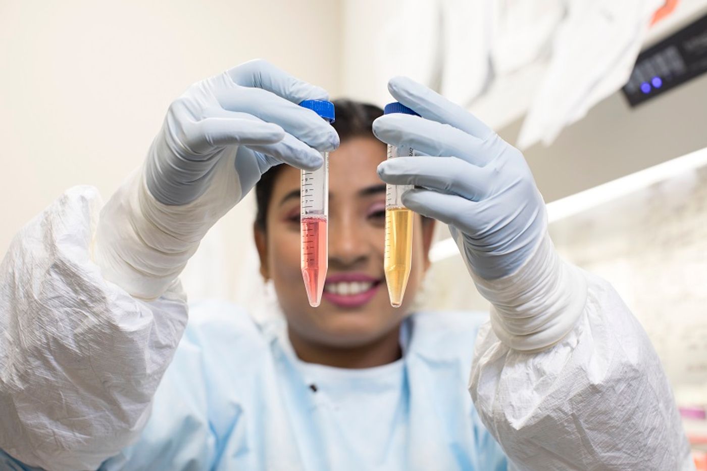 Dr. Anwesha Sanyal indicates HIV-infected cells collecting at the bottom of a vial being prepared for Pitt Public Health's TZA test. Credit: Tim Betler/UPMC