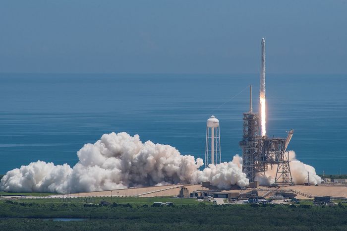A SpaceX Falcon 9 takes off from an unrelated launch pad.