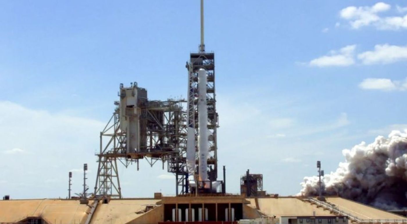 A SpaceX Falcon 9 rocket sits at a launch site awaiting launch orders.