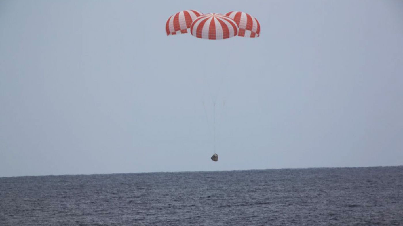 SpaceX Dragon spacecraft lands in the Pacific Ocean via parachute.
